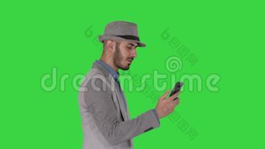 一个男人拿着手机在<strong>绿色</strong>屏幕上<strong>上网</strong>，用彩色键。